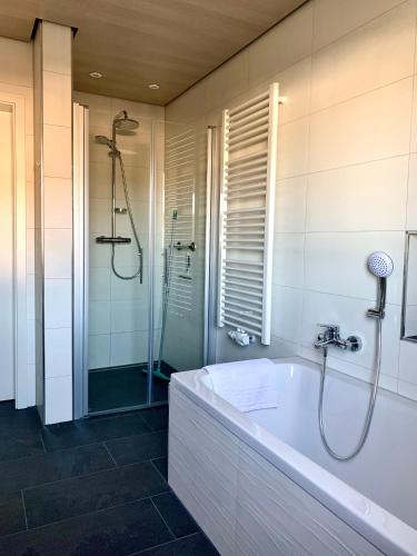 a bathroom with a bath tub and a shower at Ferienwohnung Waldhütter in Schwarzenbach an der Saale