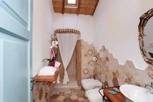 a bathroom with a toilet and a sink at Domo Bangone in Orosei