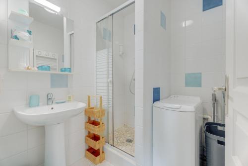 a white bathroom with a sink and a toilet at Côte d'emeraude in Saint-Benoît-des-Ondes