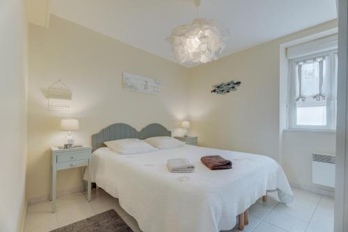 a white bedroom with a bed with a white blanket at Côte d'emeraude in Saint-Benoît-des-Ondes