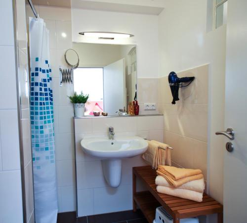 a white bathroom with a sink and a mirror at Ferienwohnung auf Ferienhof Janssen in Wangerland