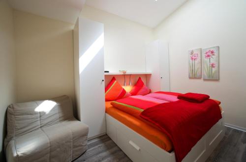 a bedroom with a red bed and a chair at Ferienwohnung auf Ferienhof Janssen in Wangerland