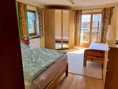 a bedroom with a bed and a desk and a window at Ferienwohnung bei Helga in Tittmoning