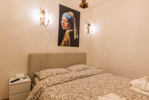 a bedroom with a bed and a painting of a girl at Wellness Lodge Edoardo in Santa Giuliana