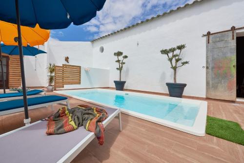 a swimming pool in a house with an umbrella at Casa Bica D'Alva in Vila Alva