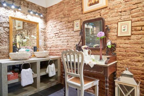 a bathroom with a vanity with a mirror and a chair at Casa Bica D'Alva in Vila Alva
