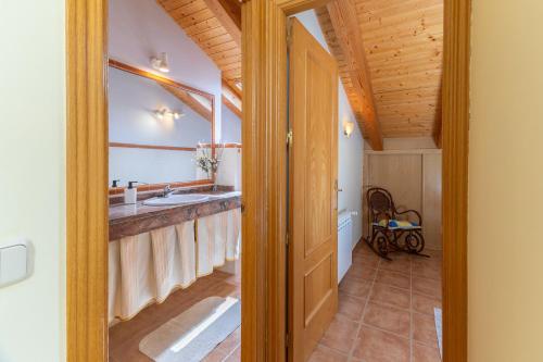 a bathroom with a sink and a wooden ceiling at La Casa de Dafne Almendro in Santo Tomé del Puerto