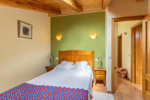 a bedroom with a bed and a green wall at La Casa de Dafne Almendro in Santo Tomé del Puerto