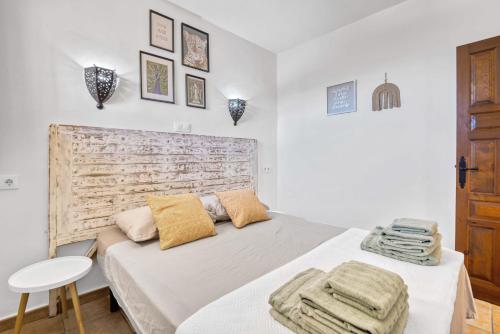 a white bedroom with a bed and a wooden headboard at Dulce Amor in Casas Abiar