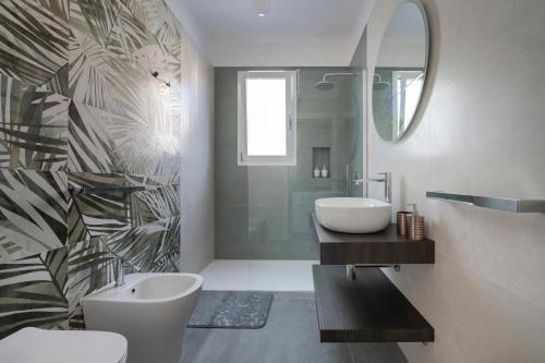 a bathroom with a toilet and a sink and a mirror at Briamar Residence in Torre dell'Orso