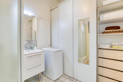 a white bathroom with a toilet and a sink at Appart - Sète quartier des Artistes in Sète