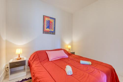 a bedroom with a bed with a red blanket at Appart - Sète quartier des Artistes in Sète