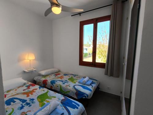 two beds in a small room with a window at Sol Isla - Binimar in Arenal d'en Castell