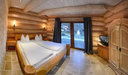 a bedroom with a bed in a log cabin at Seehaus Alm in Ruhpolding