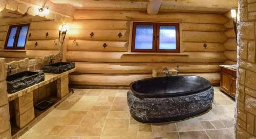 a bathroom with a large tub in a log cabin at Seehaus Alm in Ruhpolding