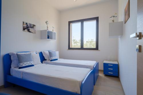 a bedroom with two beds and a window at Villa Scoglio in Melendugno