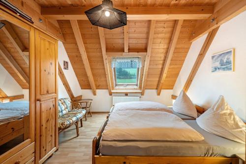 two beds in a room with wooden ceilings at Hornihäusle in Aufʼm Bühl