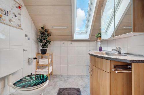 a bathroom with a toilet and a sink and a window at Großzügige Maisonettewohnung in Sindelfingen