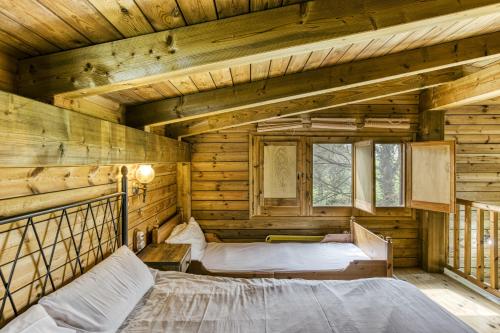 a bedroom with two beds in a log cabin at Habitacions Mas Fuselles in Girona