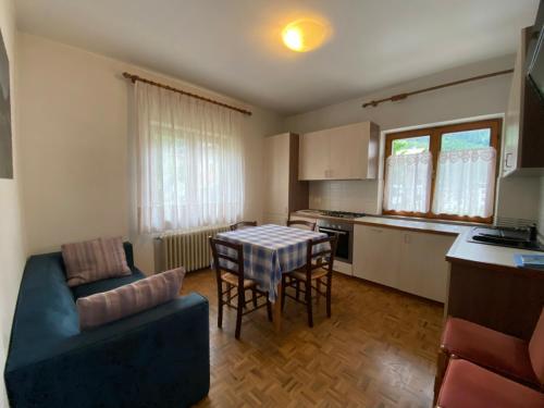 a kitchen and living room with a table and a couch at Ciasa Da Rin in Auronzo di Cadore