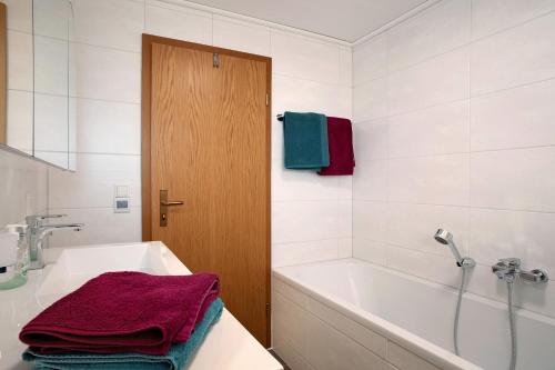 a bathroom with a white tub and a sink and a shower at Bodensee Apartment Gresser in Meckenbeuren