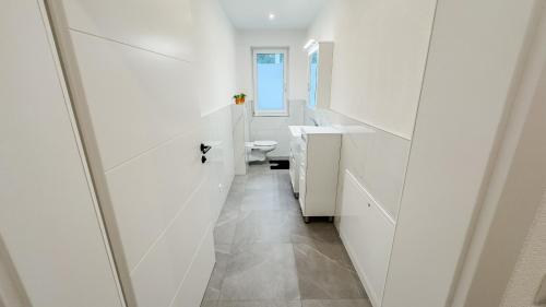 a white bathroom with a sink and a toilet at Ferienhaus Koca in Imsterberg