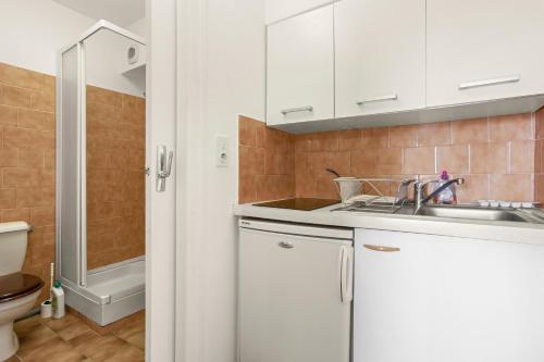 a white kitchen with a sink and a toilet at Le Mas Berliat N°9 in Bormes-les-Mimosas
