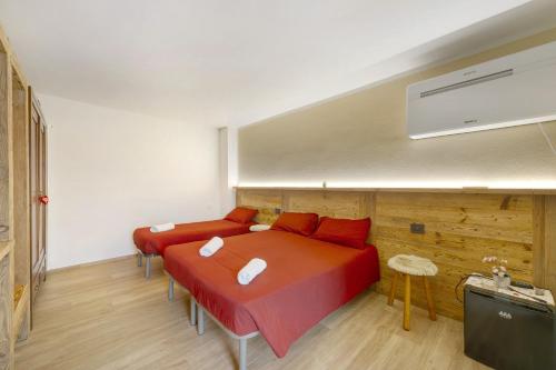 a bedroom with two beds with red sheets at Agriturismo La Grange in Pont-Saint-Martin
