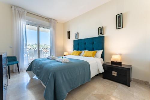 a bedroom with a large bed with a blue headboard at Apartamento Los Iris in Mijas