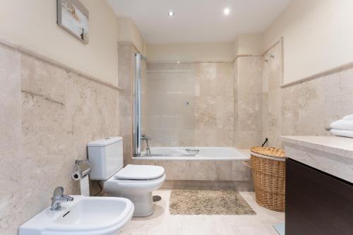 a bathroom with a toilet and a tub and a sink at Apartamento Los Iris in Mijas