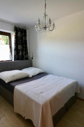 a bedroom with a bed with a chandelier at Biburg86420 in Biburg