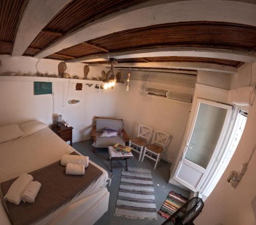 a bedroom with a bed and a chair and a window at Seagull Syros Seaside in Ermoupoli