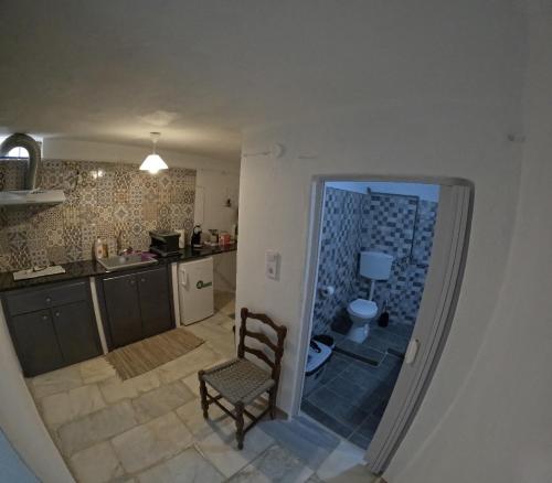 a view of a kitchen with a chair and a sink at Seagull Syros Seaside in Ermoupoli