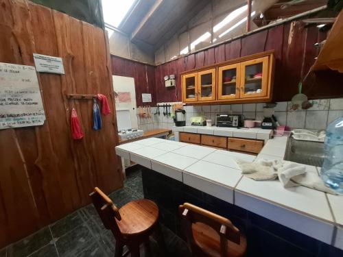 a kitchen with a counter and two chairs in it at Hotel Lucy in Montezuma