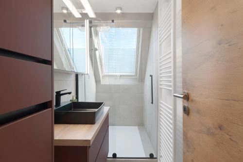a bathroom with a sink and a mirror and a window at Caroline Magg in Lindau