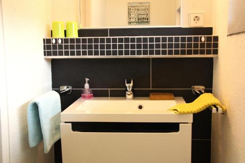 a bathroom with a white sink and a mirror at Ferienwohnungen Pano in Friedrichshafen
