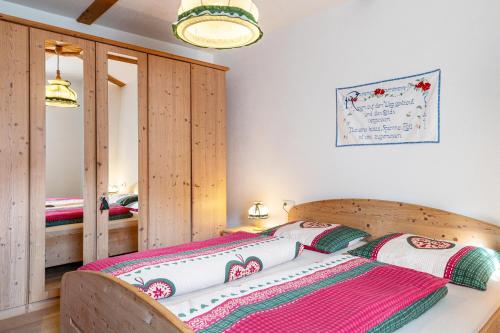 a bedroom with a bed with a wooden headboard at Thomasegg Hof Birke in Sarntal