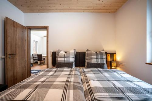 ein Schlafzimmer mit einem großen Bett und zwei Kissen in der Unterkunft Ferienhaus Tiny Time in Krumbach