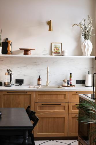 a kitchen with wooden cabinets and a sink at Vaksali Apartment, kaks minutit Ugalast in Viljandi