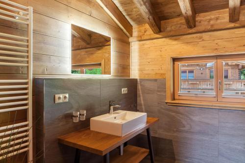 a bathroom with a sink and a wooden wall at Mountainlodge in Leutasch