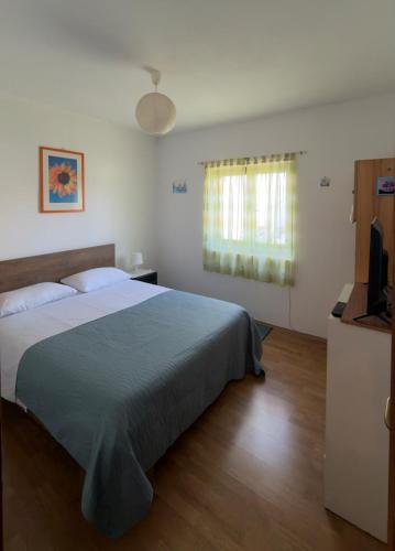 a bedroom with a large bed and a television at Laura Apartment in Tribunj