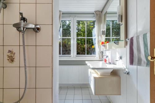 a bathroom with a shower and a sink and a window at Atlanta Pur in Pellworm