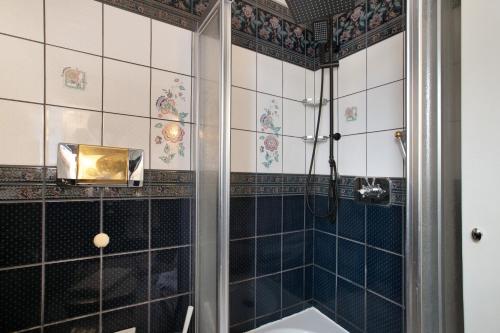 a bathroom with a shower with black and white tiles at Sylt Ferienwohnung 4 Westerland in Westerland