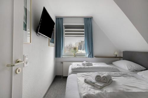 a hotel room with two beds and a window at Sylt Ferienwohnung 4 Westerland in Westerland