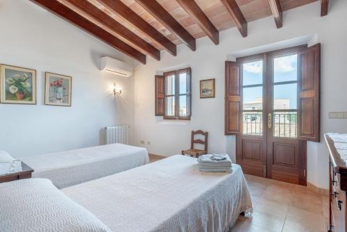 a hotel room with two beds and a window at S'era in Santanyi