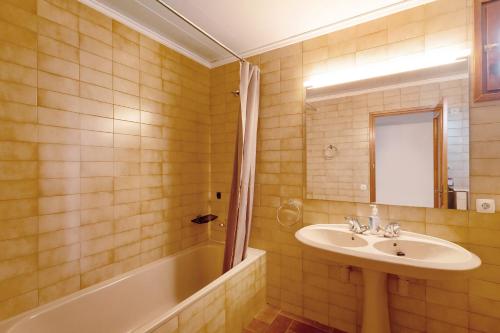 a bathroom with a sink and a bath tub at Casanova de Noet in Aviá