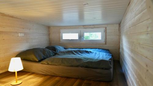 a bed in a small room with a window at Tiny House Nr 2 in Schwielowsee