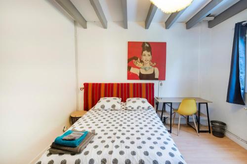 a bedroom with a bed and a desk and a painting at Vacances Pays Basque in Bidart