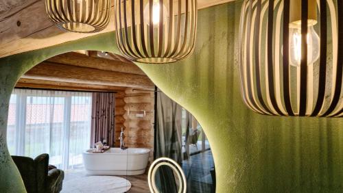 a bathroom with a green wall with chandeliers at Naturstamm Chalets in Untergriesbach