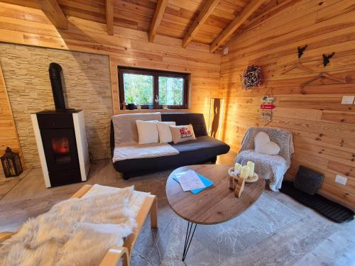 a living room with a couch and a table in a cabin at Le Chalet Cocon et Jacuzzi in La Petite-Pierre